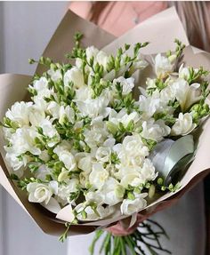 a woman holding a bouquet of white flowers