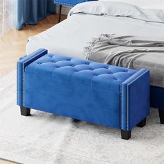 a blue bench sitting on top of a bed in a bedroom next to a white rug