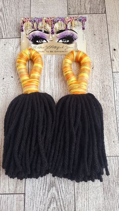 two skeins of black yarn with orange and yellow rings on top of them