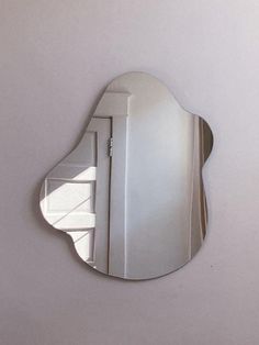 a mirror that is on the wall with a reflection of it's own door