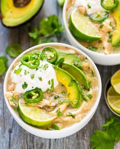 two white bowls filled with chicken and avocado soup