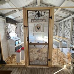 the inside of a chicken coop with an open door that leads to another room filled with chickens