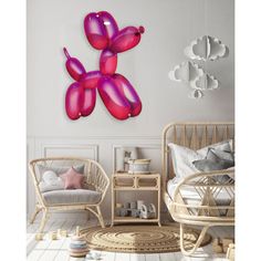 a white room with wicker furniture and pink balloons on the wall above it's bed