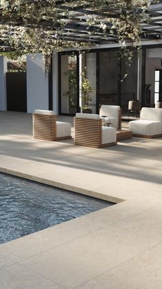 an outdoor lounge area next to a swimming pool