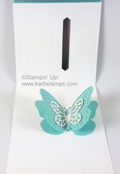 a white card with a blue butterfly on it's side and a black arrow in the middle