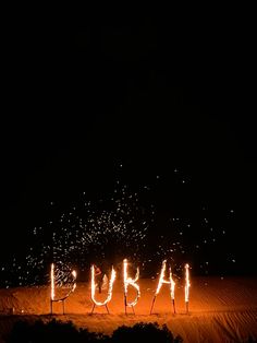 the word puba spelled out with sparkles in the dark night sky above sand dunes