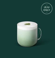 there is a cup that has been placed on the table with its lid open and it's in front of a green background