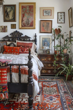 a bed sitting in a bedroom next to a bunch of framed pictures on the wall