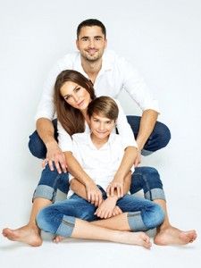 a man, woman and child are sitting on the floor with their arms around each other