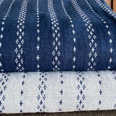 two blue and white blankets sitting on top of each other