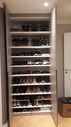 a closet filled with lots of shoes next to a door and a shoe box on the floor