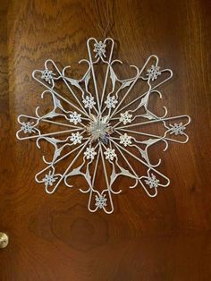 a metal snowflake hanging from the side of a door