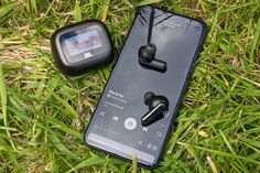 an mp3 player and ear buds laying in the grass