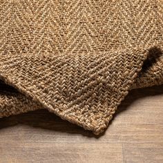 a close up view of the top of a rug on a wooden floor with wood floors