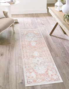 a large rug on the floor in a living room with white walls and wooden floors