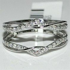 two white gold wedding rings with diamonds on top of each other and one diamond in the middle