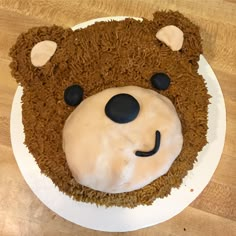 a cake shaped like a teddy bear with icing on it's face and ears