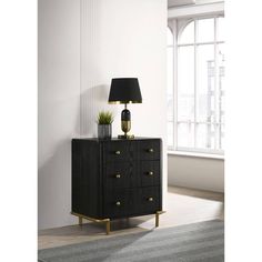 a black and gold chest of drawers with a lamp on top in front of a window