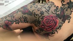 the back of a woman's shoulder with tattoos on it and a red rose