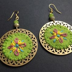 the earrings are decorated with green and yellow flowers on it's earwires