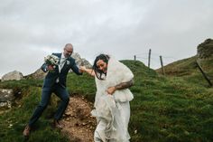 a bride and groom walking up a hill