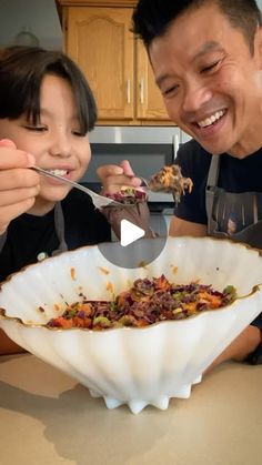 a man and woman eating food out of a bowl