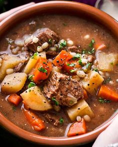 a bowl filled with stew and vegetables on top of a table