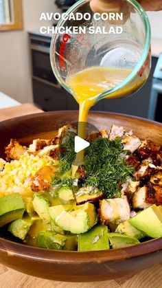 someone pouring dressing into a bowl filled with vegetables and meats to make chicken salad