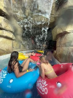 two girls are on inflatable rafts at the water park