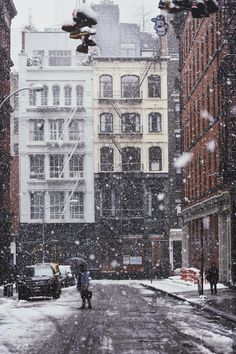 people walking in the snow on a city street