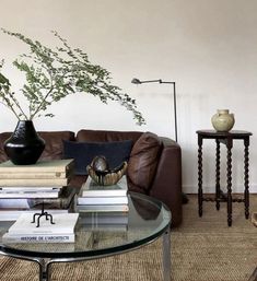 a living room filled with furniture and a glass top coffee table topped with lots of books