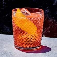 an orange colored drink in a glass on a table