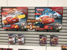 some toys are hanging on the wall in front of other toy display items at a store