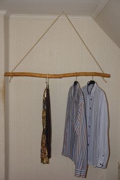 three shirts hanging on a clothes rail in a room