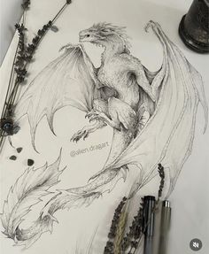 a pencil drawing of a dragon on paper