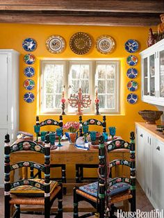 an image of a dining room with yellow walls and mexican style decorations on the wall