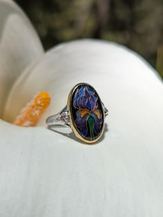 For me the Iris is a symbol of my mother and her love of gardening. She would work tirelessly to plant iris bulbs, her favorite flower, in the preparation for spring. Irises are also associated with symbols of hope, wisdom, trust and valour. This lovely ring is made from glass enamel, fine silver, 24k and 22k gold, and peach topaz set in a sterling silver band. This ring is made to order to your perfect fit and will take 2-4 weeks from order to shipping to make. Vintage Metal Jewelry, Plant Iris Bulbs, Symbols Of Hope, Iris Bulbs, Natural Stone Rings, Iris Ring, Flower Rings, Favorite Flower, Dope Jewelry