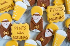 some decorated cookies are sitting on a marble counter top with the words pints with aguinas