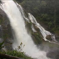 a large waterfall in the middle of a forest