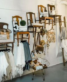 a room filled with lots of different types of clothes and furniture on display in front of a white wall