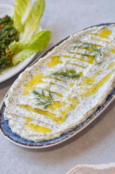 a blue plate topped with hummus next to a salad