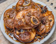 a white plate topped with lots of food on top of a wooden table next to a basket