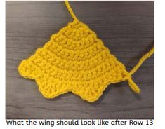 a yellow crocheted object on top of a wooden table with the words, what the wing should look like after row 13