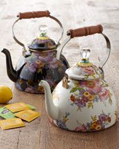 two tea kettles sitting next to each other on a table