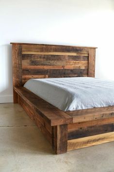 a bed made out of wood and white sheets