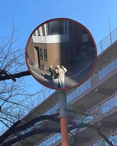 the reflection of two people standing in front of a building is shown in a mirror