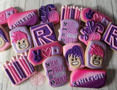 some decorated cookies are laying on the table with pink and purple icing around them