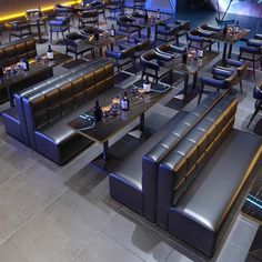 an empty restaurant with blue leather booths and tables in the center, all lit up by neon lights