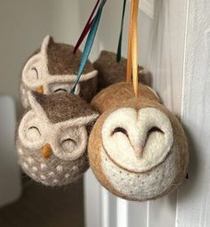 two stuffed owls hanging from hooks on a door