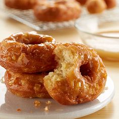 two donuts are stacked on top of each other in front of another plate with more donuts behind them